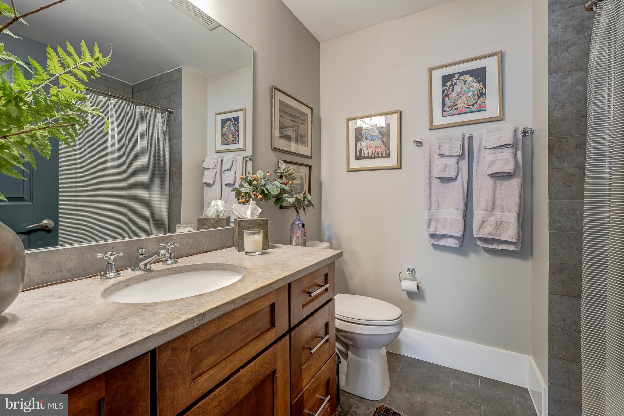 1600 Clarendon Boulevard, Unit W108 Arlington, VA 22209 - Photo 28 of 50 a bathroom with a granite countertop sink toilet and a mirror