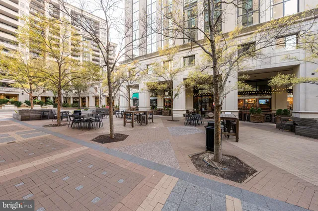 a group of people sitting on a sidewalk in front of building