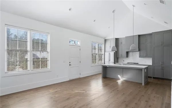 a kitchen with stainless steel appliances a sink a stove a refrigerator and cabinets