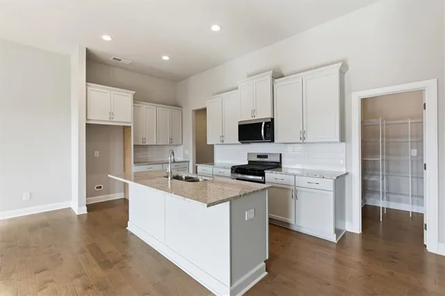 a large kitchen with cabinets and stainless steel appliances