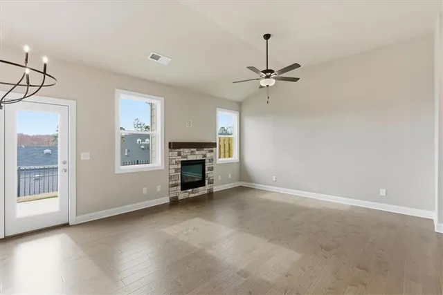an empty room with windows and ceiling fan