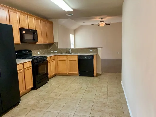 a large kitchen with cabinets and stainless steel appliances