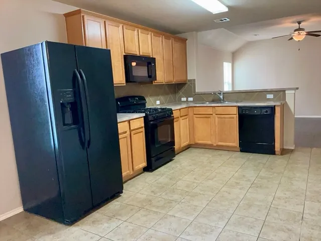a kitchen with stainless steel appliances granite countertop a stove a refrigerator and a microwave