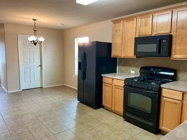 a kitchen with stainless steel appliances granite countertop a stove a refrigerator and a microwave