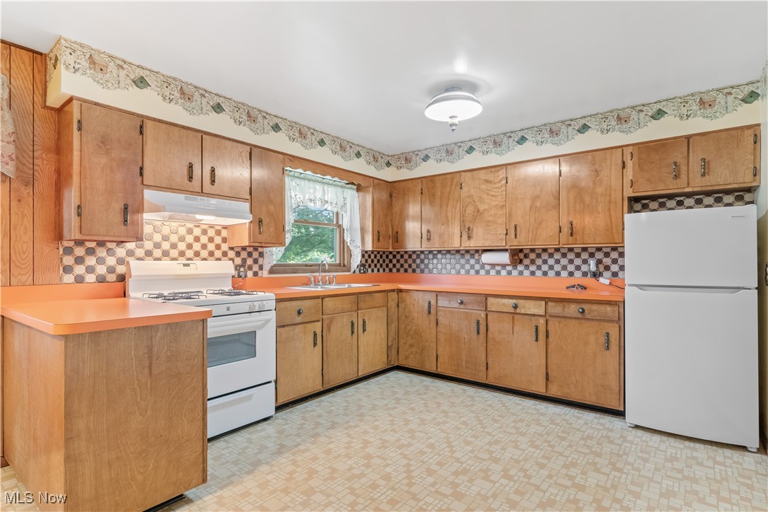 900 Ryan Road Medina, OH 44256 - Photo 12 of 40 Kitchen featuring light tile patterned floors, tasteful backsplash, white appliances, and sink