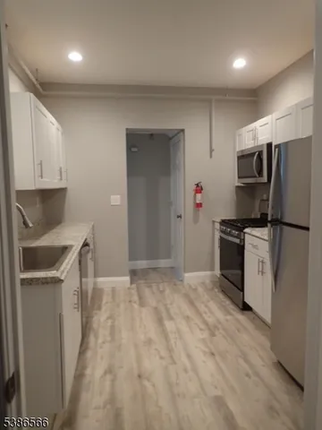 a kitchen with granite countertop a refrigerator and a sink
