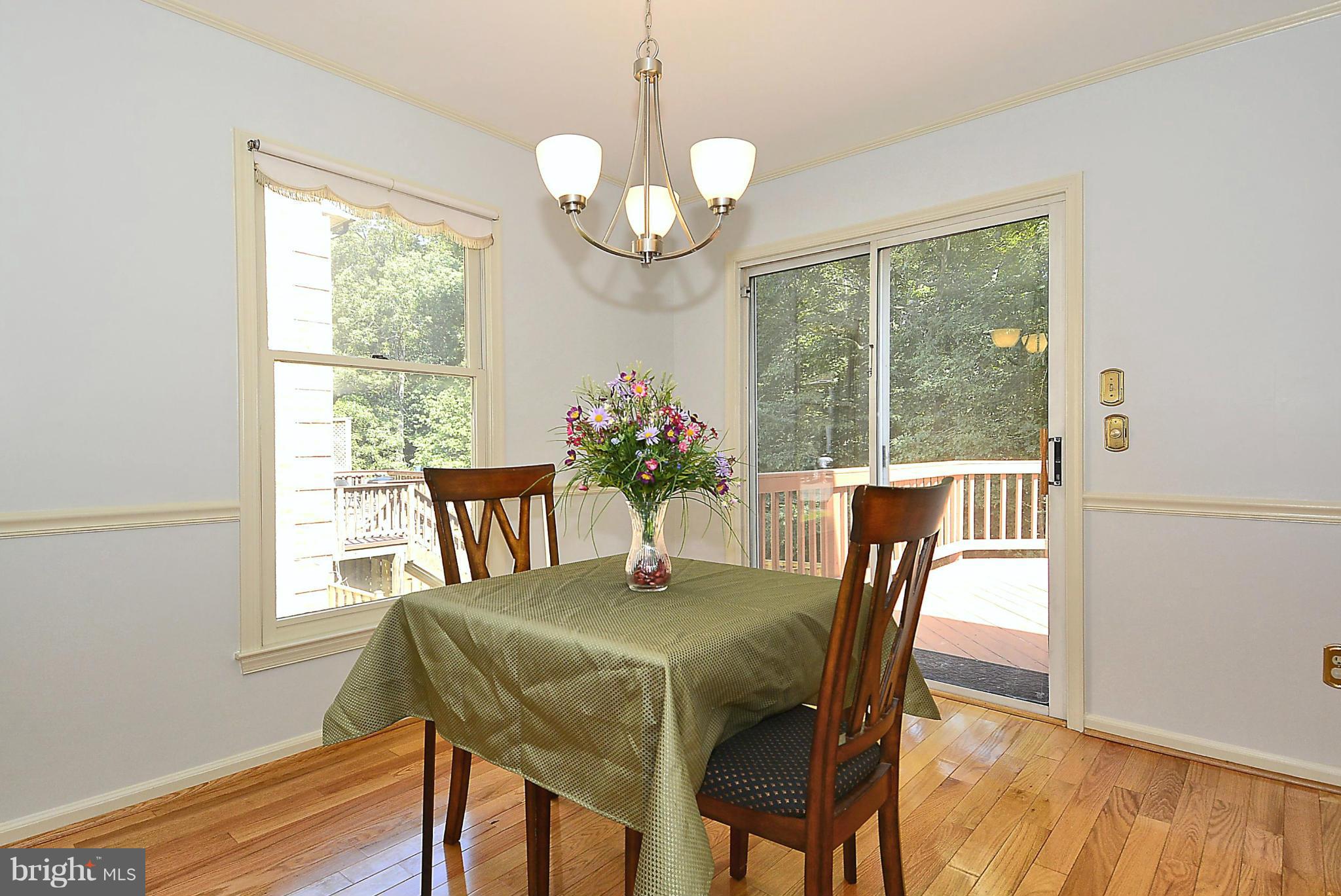6277 Rathlin Drive Springfield, VA 22152 - Photo 9 of 30 a dining room with wooden floor and a chandelier