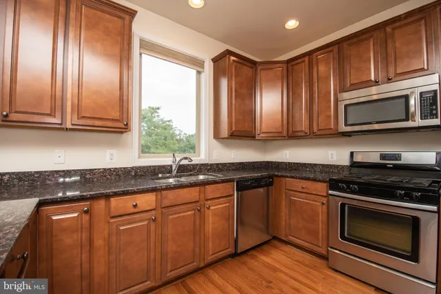 a kitchen with granite countertop cabinets and refrigerator
