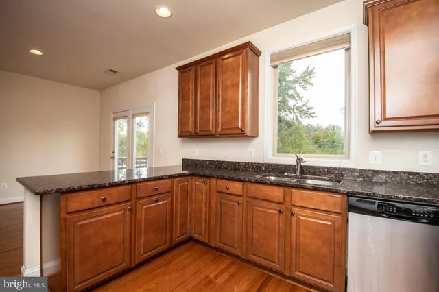 a kitchen with granite countertop wooden cabinets and stainless steel appliances