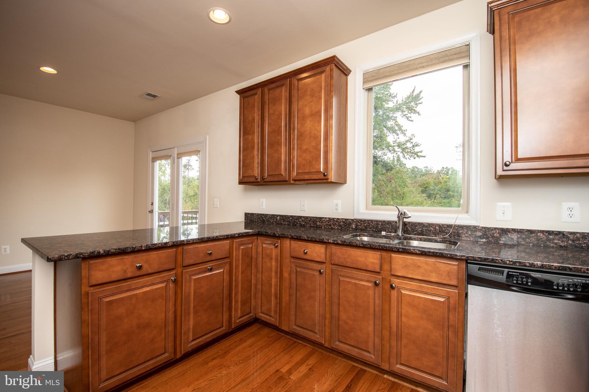 22199 Falling Terrace Ashburn, VA 20148 - Photo 27 of 58 a kitchen with granite countertop wooden cabinets sink and window