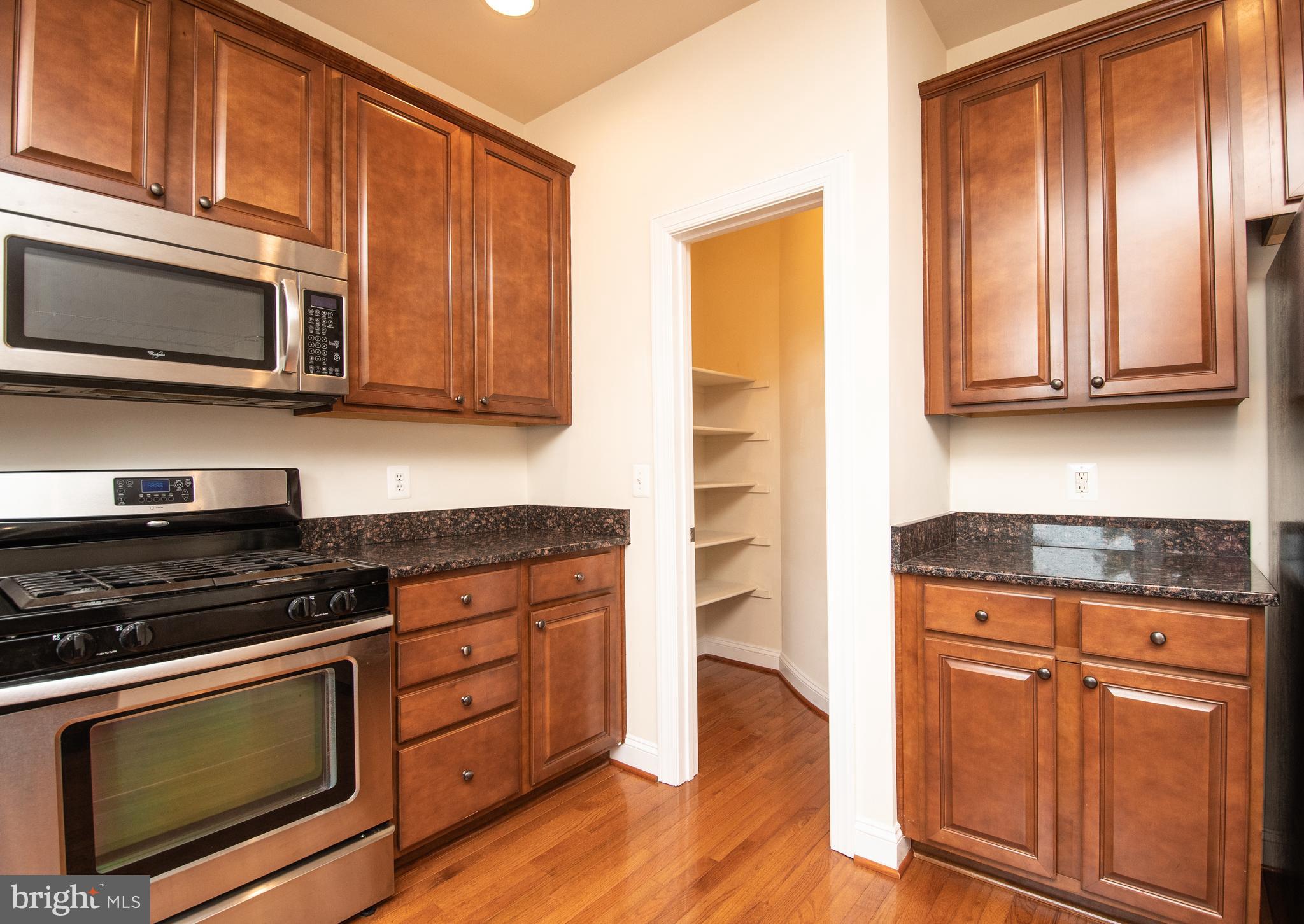 22199 Falling Terrace Ashburn, VA 20148 - Photo 29 of 58 a kitchen with granite countertop wooden cabinets and stainless steel appliances
