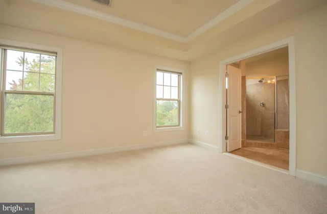 an empty room with closet and windows
