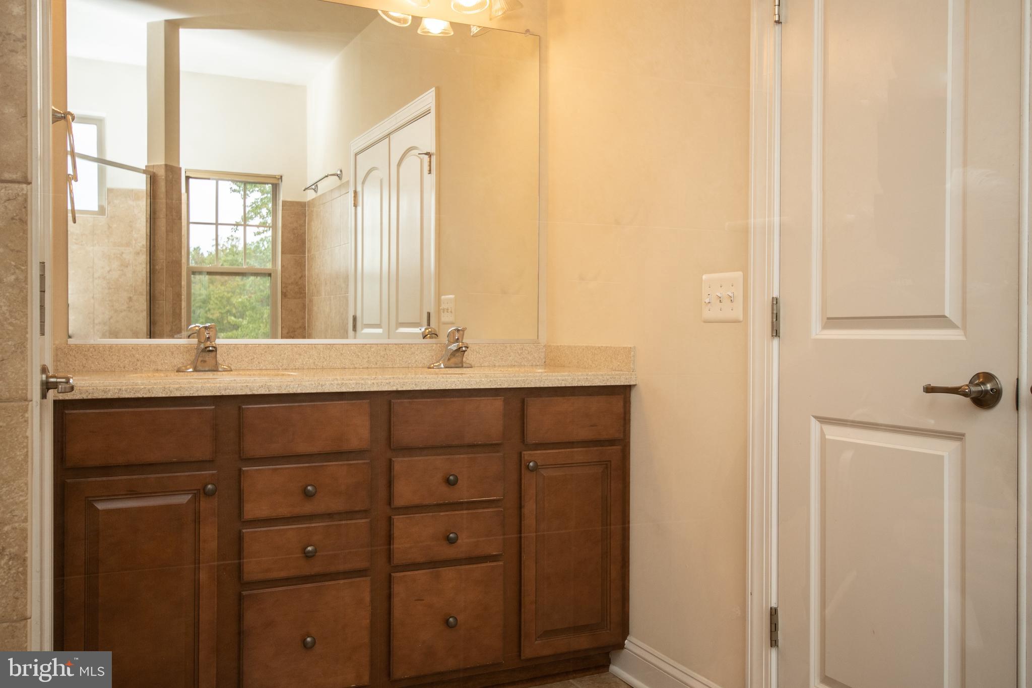 22199 Falling Terrace Ashburn, VA 20148 - Photo 41 of 58 a bathroom with a double vanity sink a mirror and a bathtub