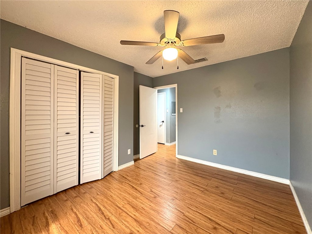 6702 Everhart Road, Unit H105 Corpus Christi, TX 78413 - Photo 12 of 18 an empty room with wooden floor closet and windows