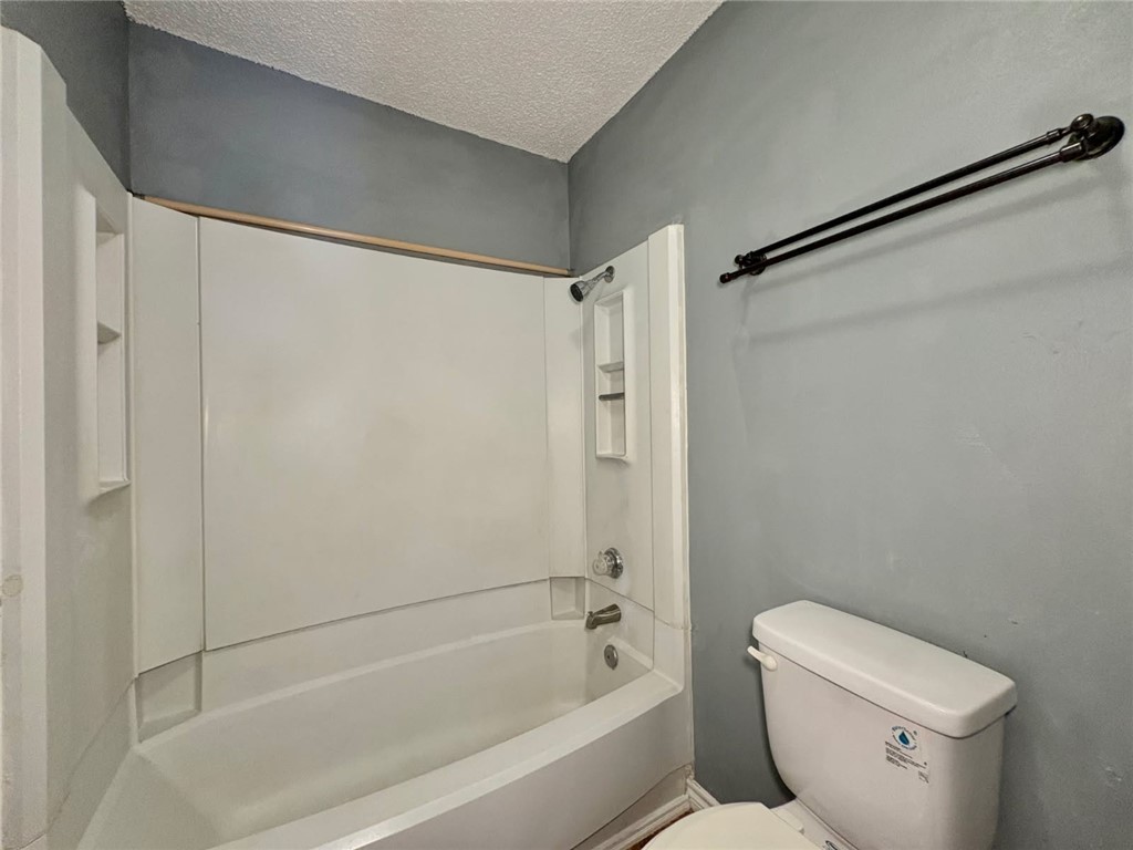 6702 Everhart Road, Unit H105 Corpus Christi, TX 78413 - Photo 13 of 18 a bathroom with a shower and a toilet
