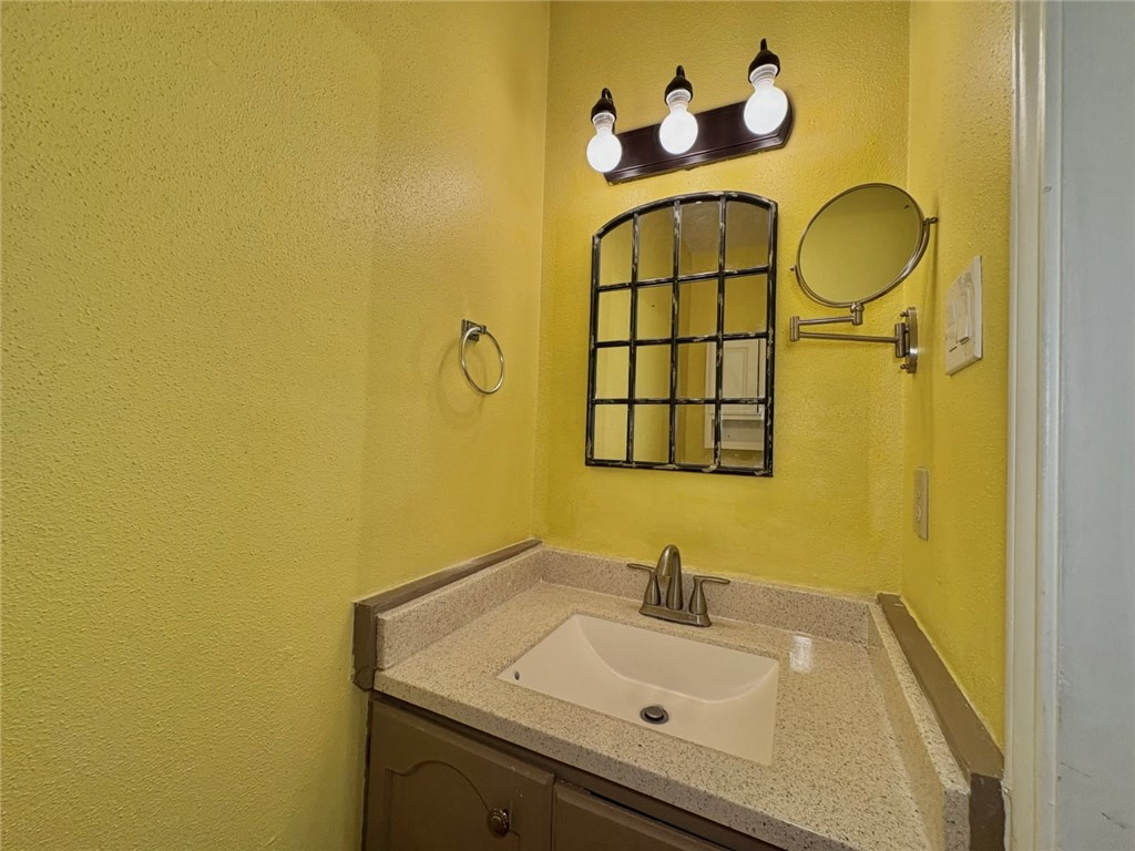 6702 Everhart Road, Unit H105 Corpus Christi, TX 78413 - Photo 16 of 18 a bathroom with a sink and a mirror
