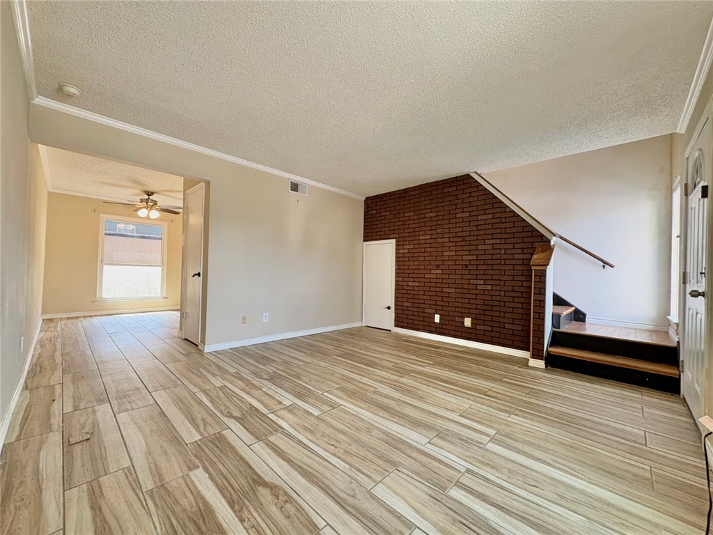 6702 Everhart Road, Unit H105 Corpus Christi, TX 78413 - Photo 2 of 18 a view of an empty room with wooden floor and a window