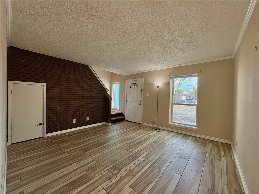 6702 Everhart Road, Unit H105 Corpus Christi, TX 78413 - Photo 3 of 18 a view of an empty room with wooden floor and windows