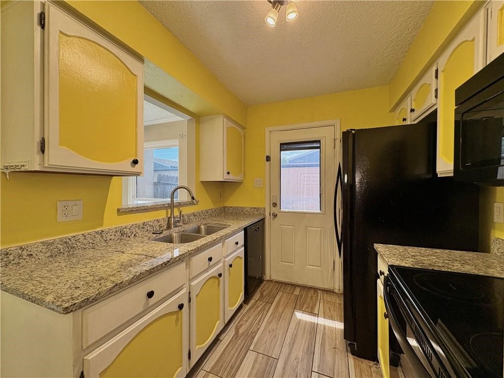 6702 Everhart Road, Unit H105 Corpus Christi, TX 78413 - Photo 7 of 18 a kitchen with stainless steel appliances granite countertop a sink and a refrigerator
