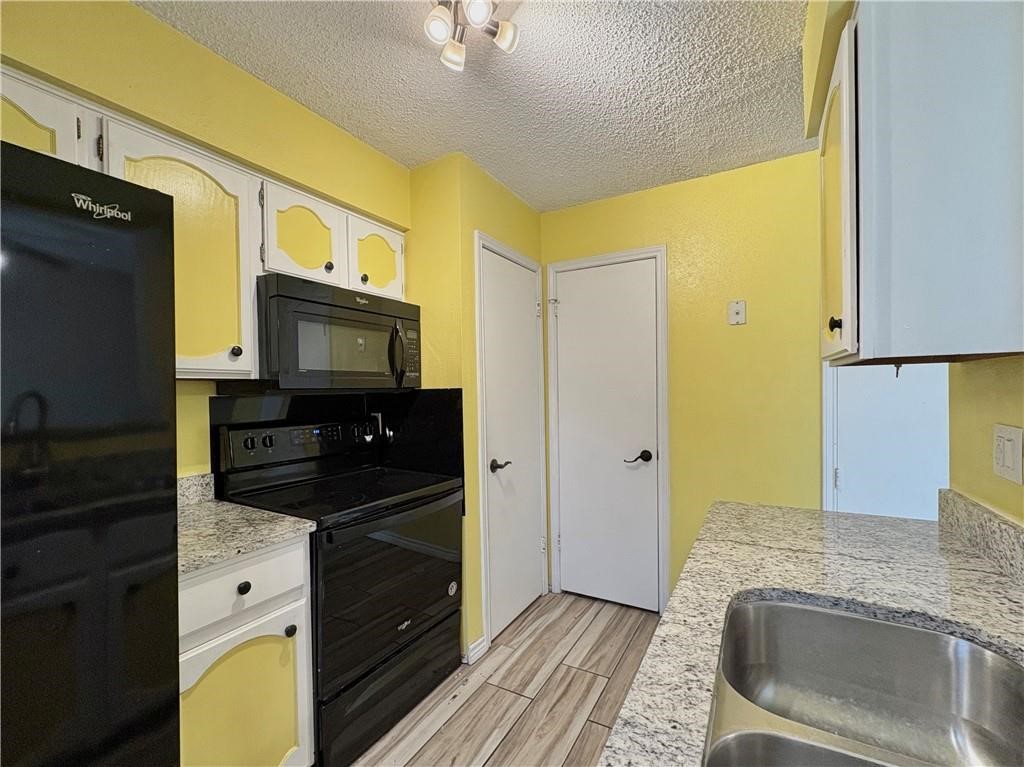 6702 Everhart Road, Unit H105 Corpus Christi, TX 78413 - Photo 8 of 18 a kitchen with stainless steel appliances granite countertop a sink and a microwave