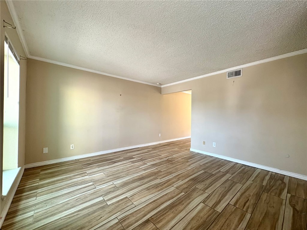 6702 Everhart Road, Unit H105 Corpus Christi, TX 78413 - Photo 9 of 18 a view of an empty room with wooden floor and a window