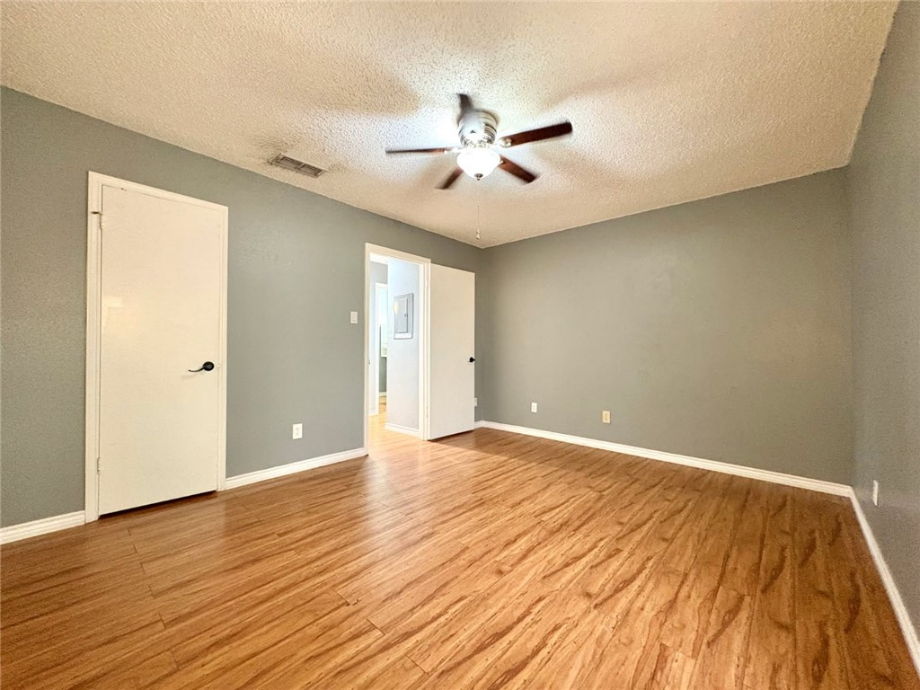 6702 Everhart Road, Unit H105 Corpus Christi, TX 78413 - Photo 10 of 18 wooden floor in an empty room with a window