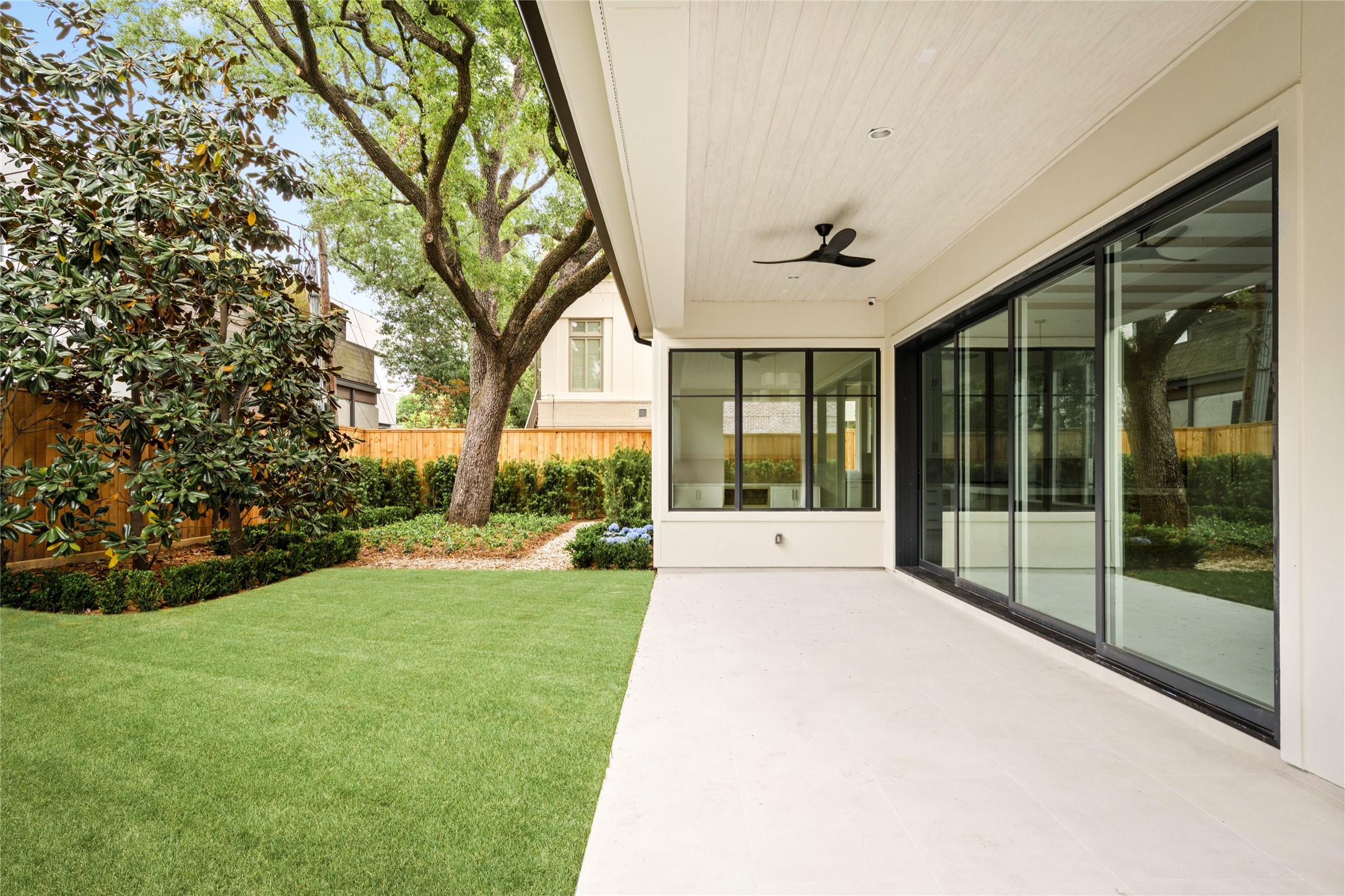 4006 Overbrook Lane Houston, TX 77027 - Photo 47 of 50 Seamless indoor-outdoor living with expansive sliding doors opening to a covered patio and manicured yard, offering room for a future pool.