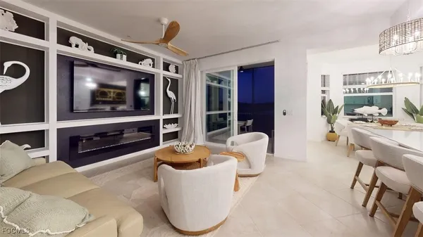 a living room with furniture a fireplace and large windows