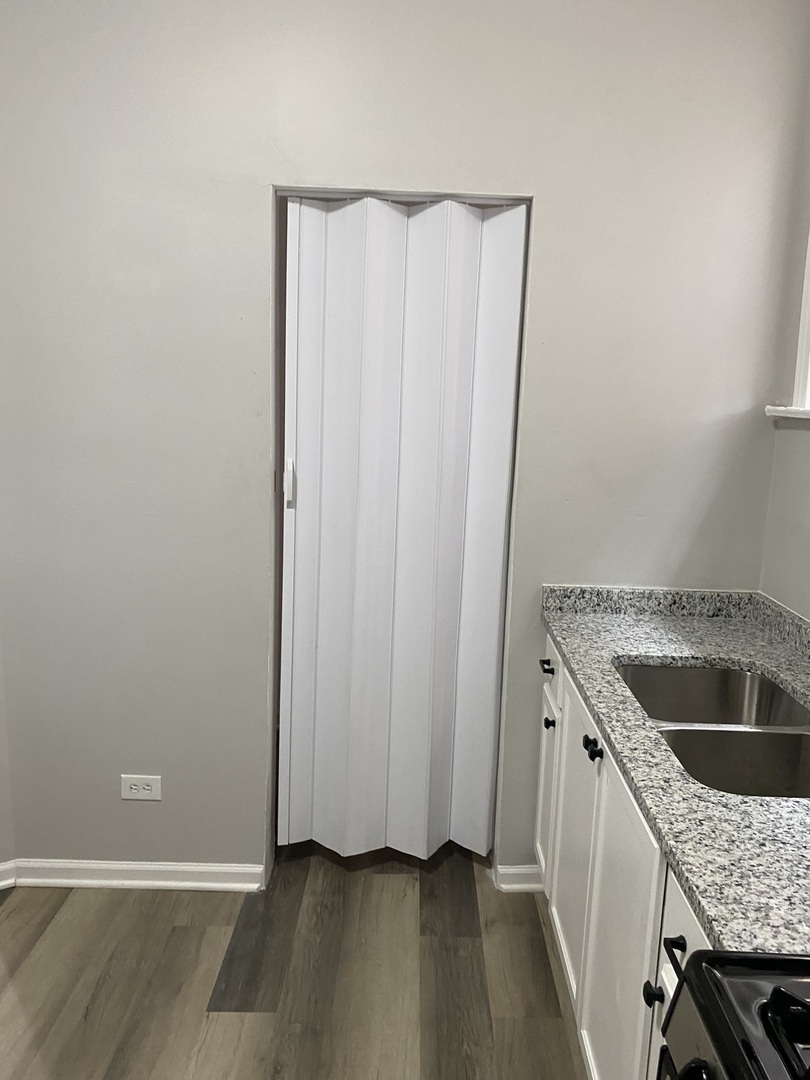 7425 South Princeton Avenue, Unit 2 Chicago, IL 60621 - Photo 11 of 24 a kitchen with a granite countertop sink and refrigerator