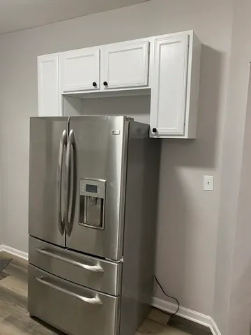 a metallic refrigerator freezer sitting in a kitchen