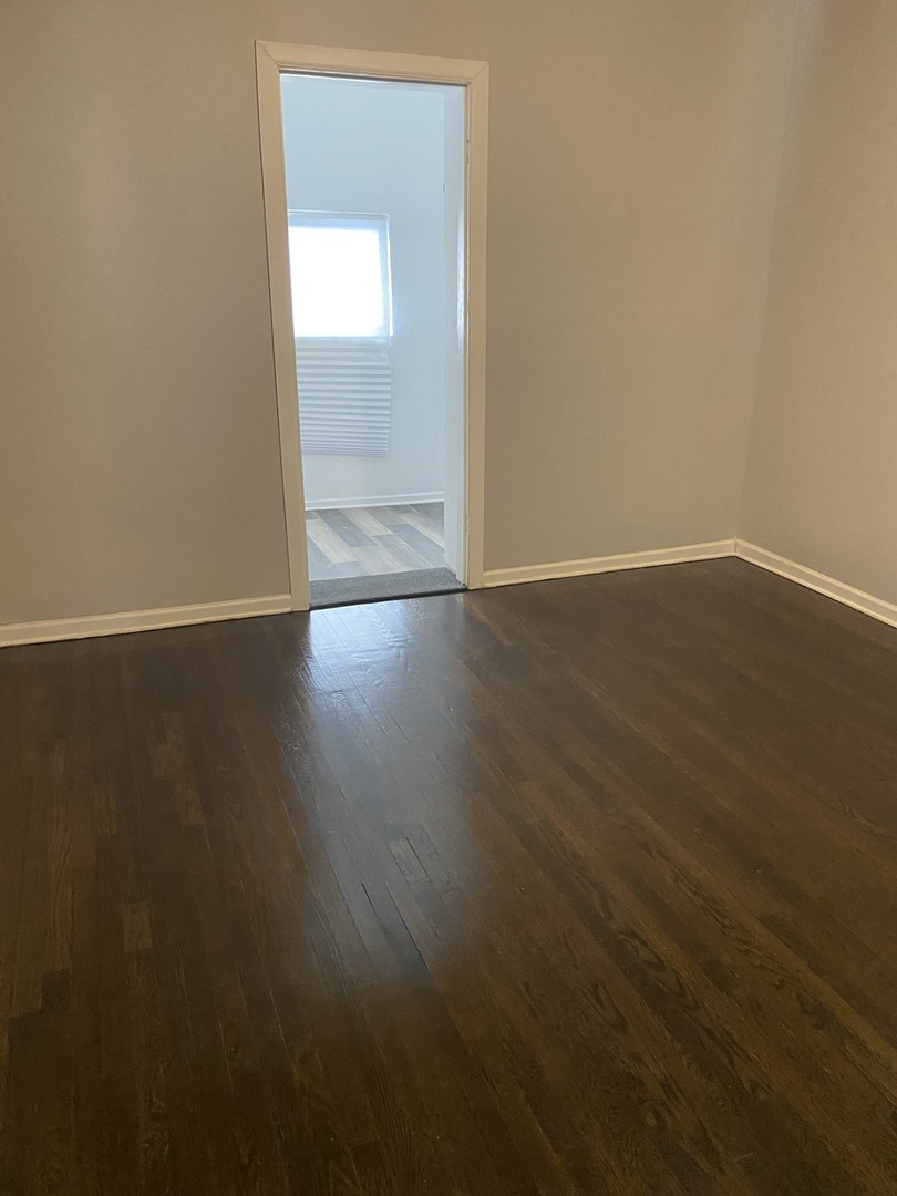 7425 South Princeton Avenue, Unit 2 Chicago, IL 60621 - Photo 20 of 24 an empty room with wooden floor and windows