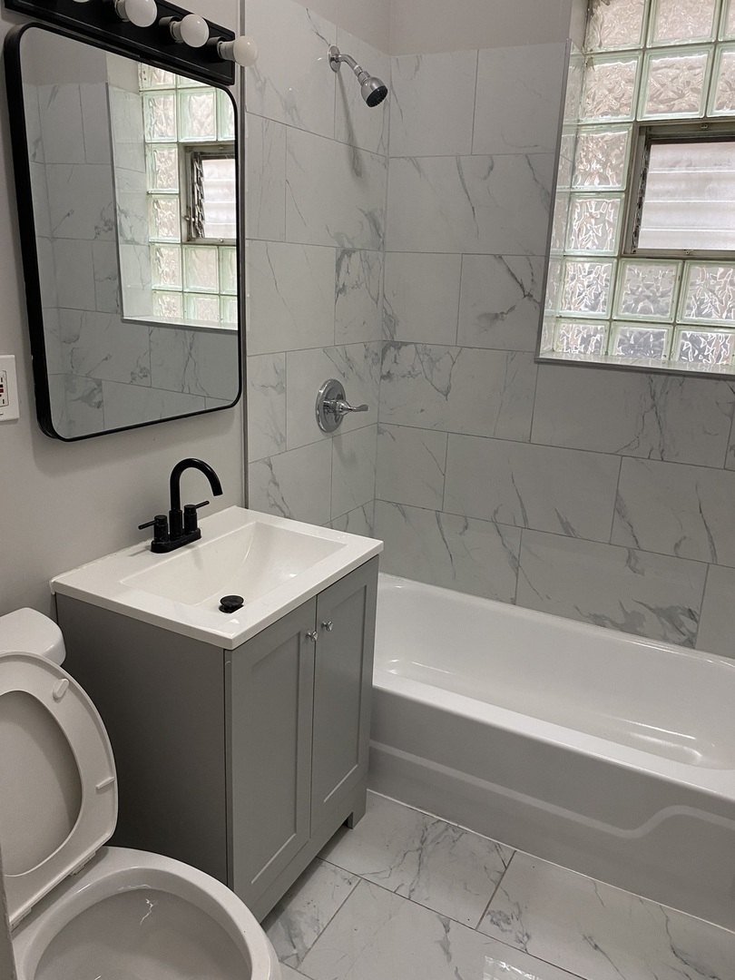 7425 South Princeton Avenue, Unit 2 Chicago, IL 60621 - Photo 6 of 24 a bathroom with a sink toilet and bathtub