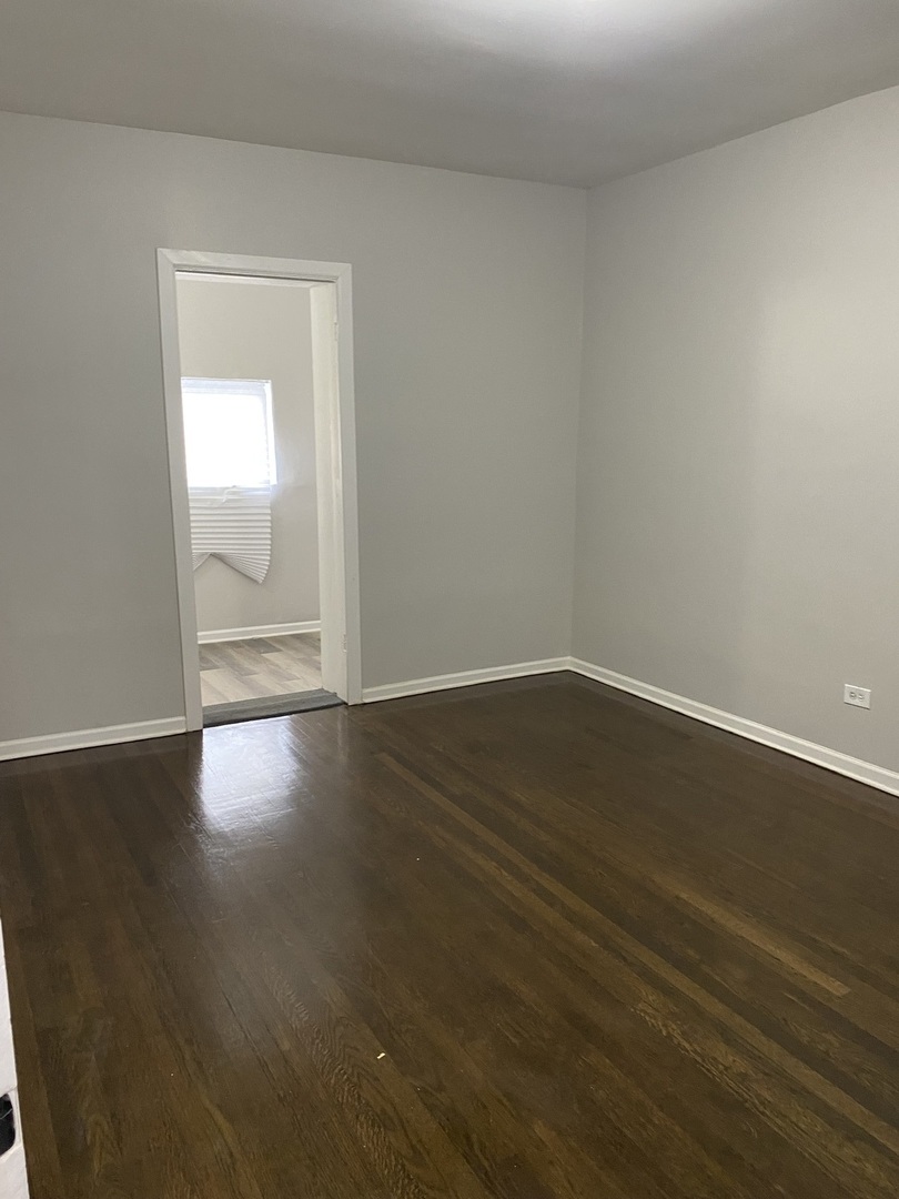 7425 South Princeton Avenue, Unit 2 Chicago, IL 60621 - Photo 8 of 24 a view of wooden floor and windows in a room