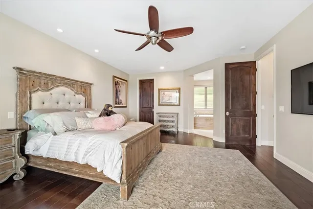 a bedroom with a large bed and a chandelier