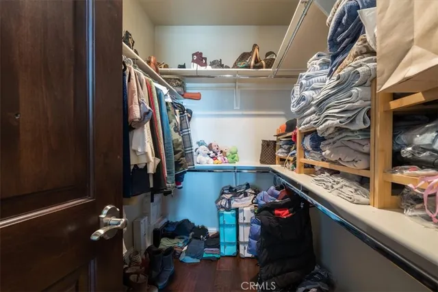 a view of walk in closet with clothes and shoes