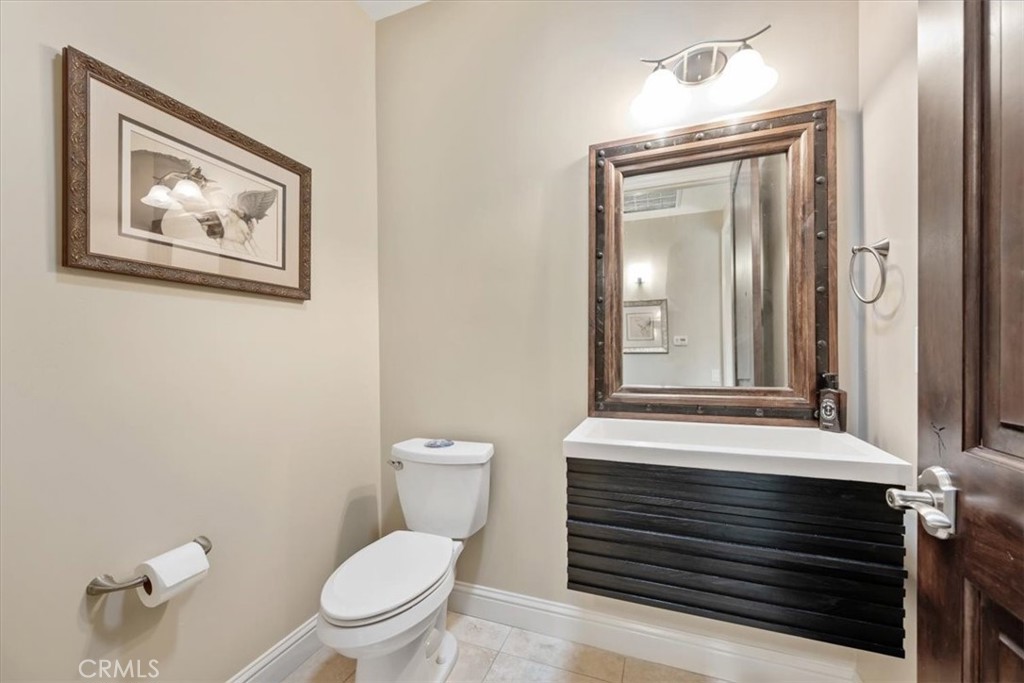 207 Princessa Lane Pismo Beach, CA 93449 - Photo 32 of 38 a bathroom with a toilet a sink and mirror