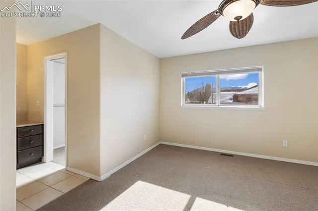 an empty room with a ceiling fan and a window