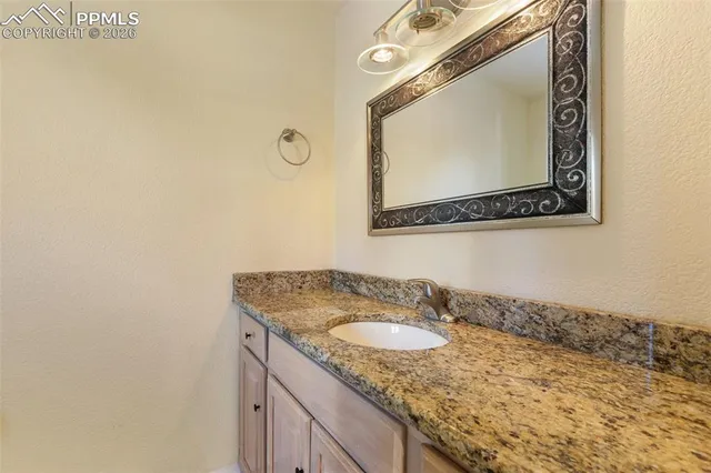 a bathroom with a granite countertop sink toilet and mirror