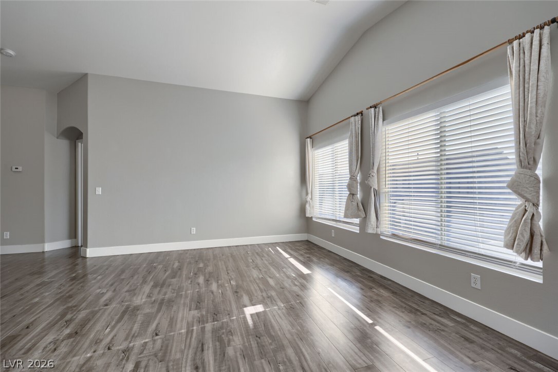 5985 High Steed Street, Unit 101 Henderson, NV 89011 - Photo 8 of 38 Tall vaulted ceilings amplify this generously proportioned living area with wood plank flooring.