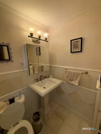 a bathroom with a sink mirror and toilet