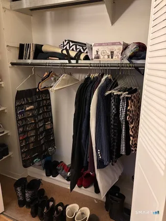a view of walk in closet with clothes and shoes