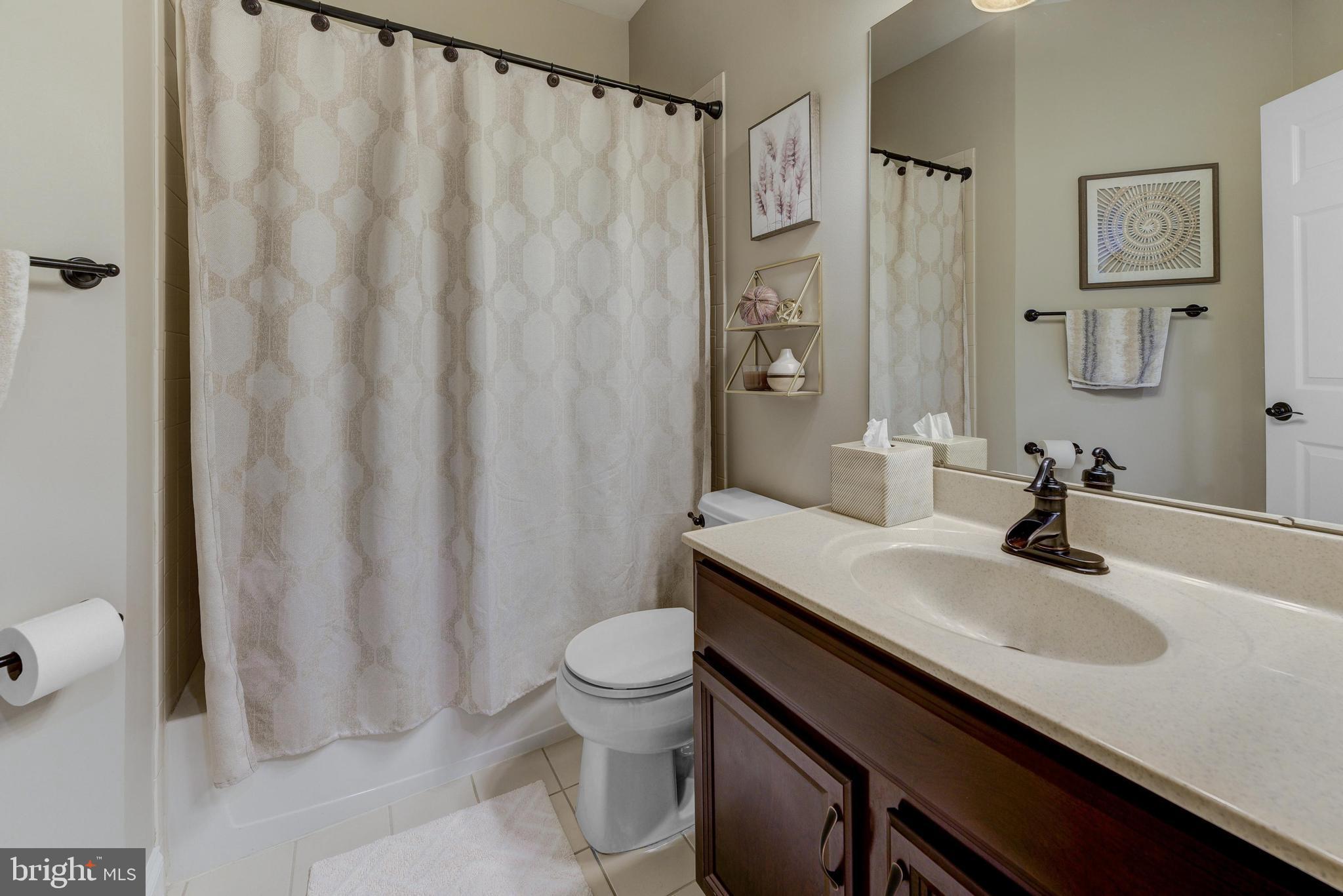 811 Castleton Drive Mickleton, NJ 08056 - Photo 9 of 52 a bathroom with a sink a toilet a mirror and shower curtain