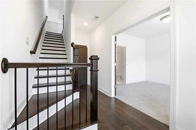a view of hallway with stairs and wooden floor
