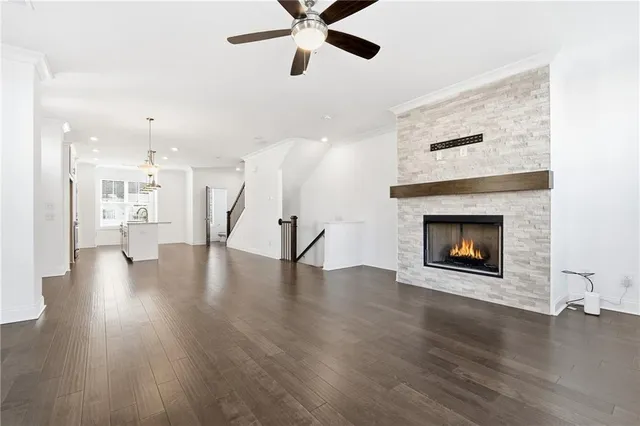 a view of an empty room with wooden floor and a fireplace