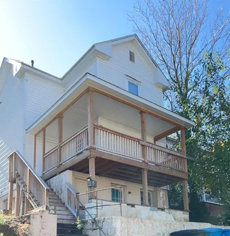a view of a house with a small yard and wooden fence