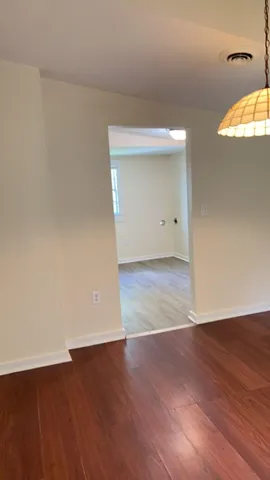 an empty room with wooden floor and a window