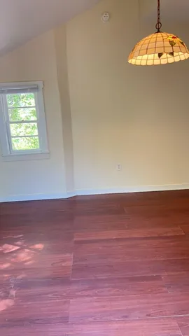 a view of an empty room and wooden floor