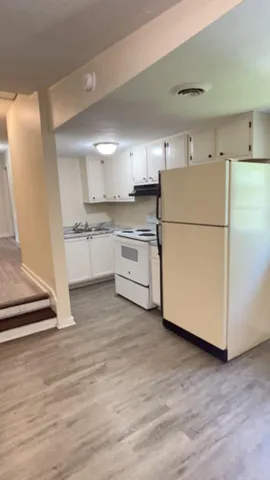 a kitchen with a refrigerator and a stove top oven