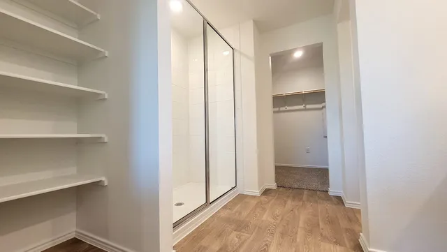 a view of an empty room with closet and a window