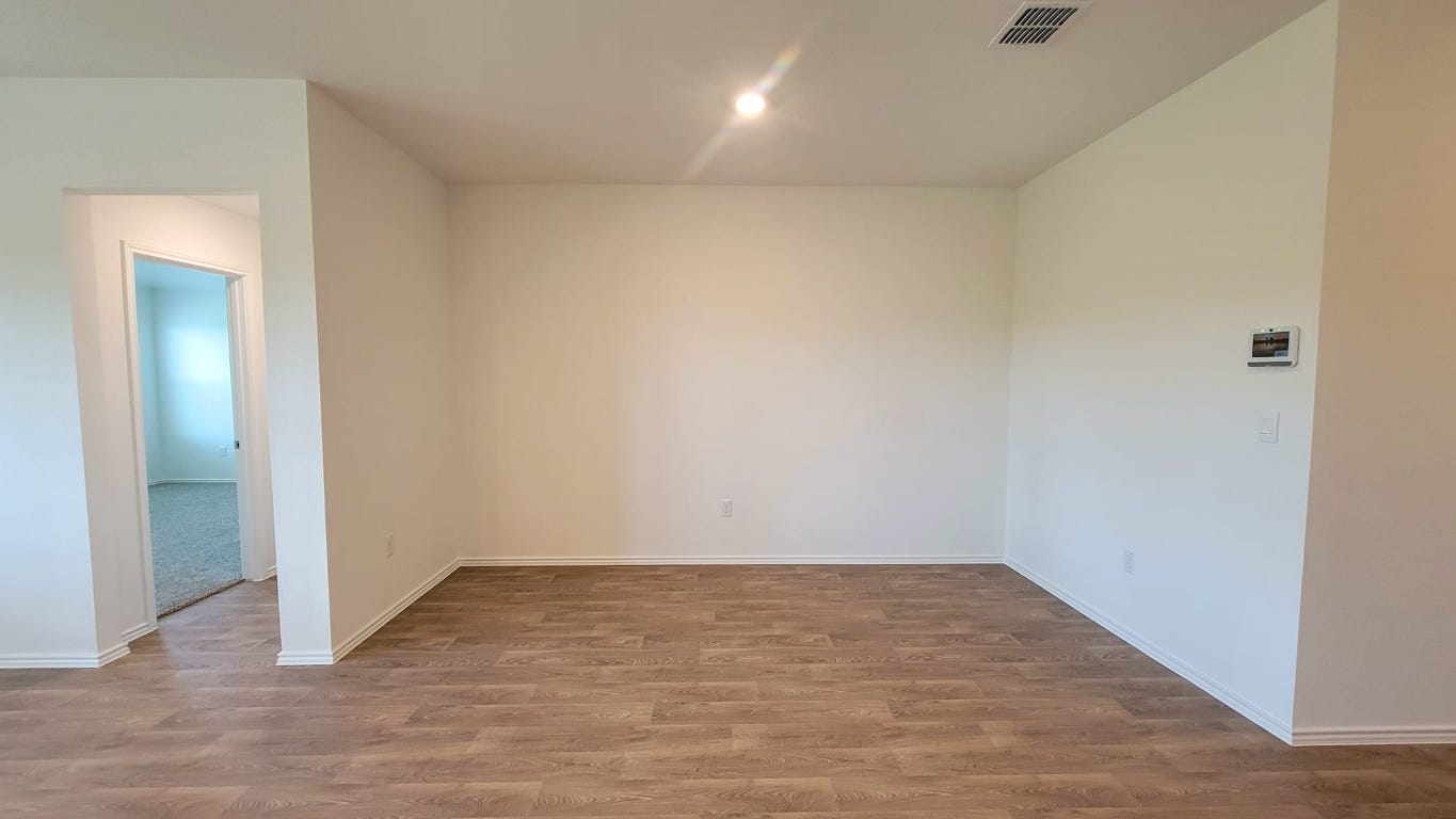 245 Texoma Street Kyle, TX 78640 - Photo 5 of 17 an empty room with wooden floor and windows